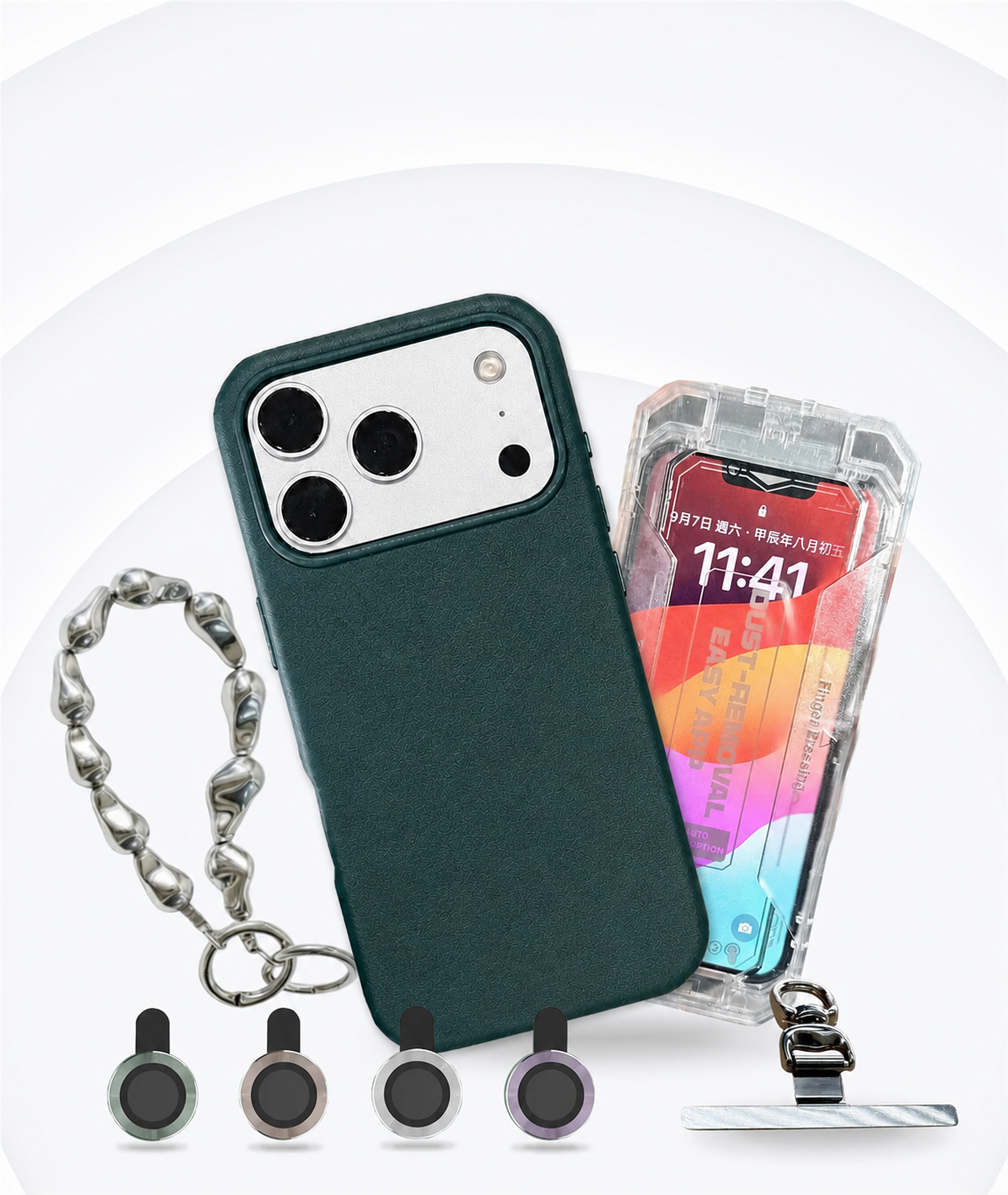 銀色 iPhone 裝上 YU 皮革MagSafe磁吸手機殼，旁邊是金屬珠鏈掛飾、四枚玻璃鏡頭環與手機夾片，另有一支盒裝手機顯示螢幕