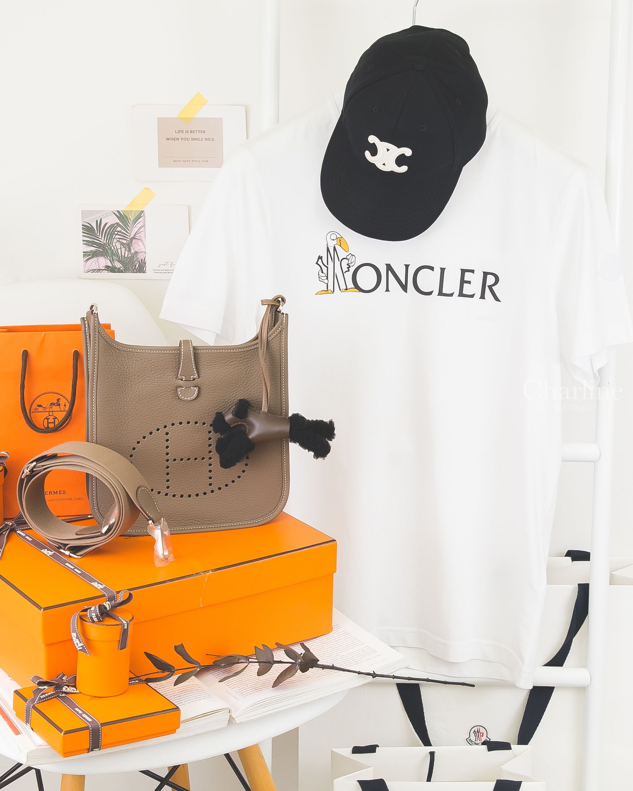 MONCLER 白色 Logo 印花圓領短袖 T-shirt 搭配黑色帽款與棕色包款情境陳列，Charline Boutique 實拍