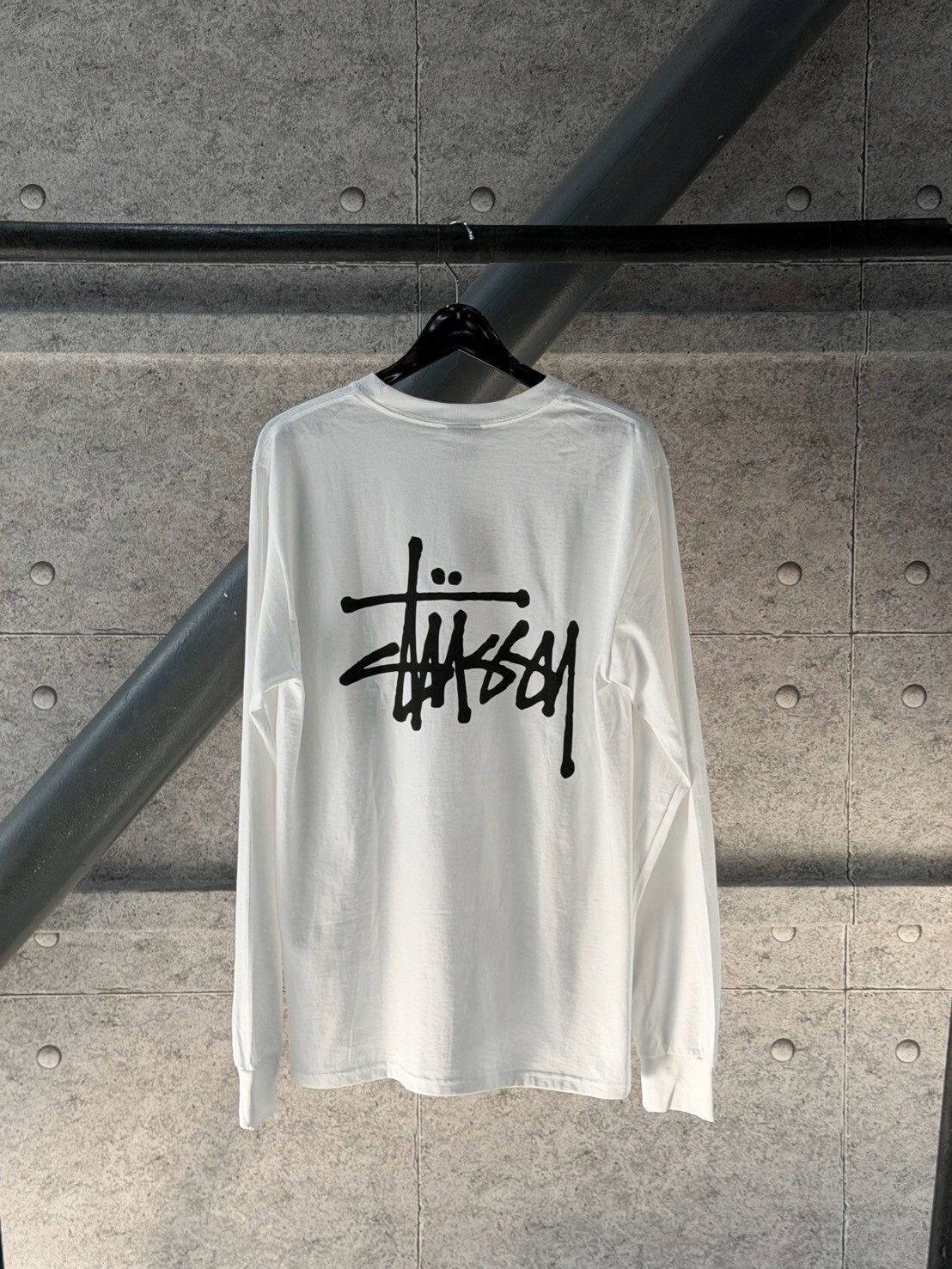 STUSSY classic style white long-sleeved T-shirt with large logo on the front and back.