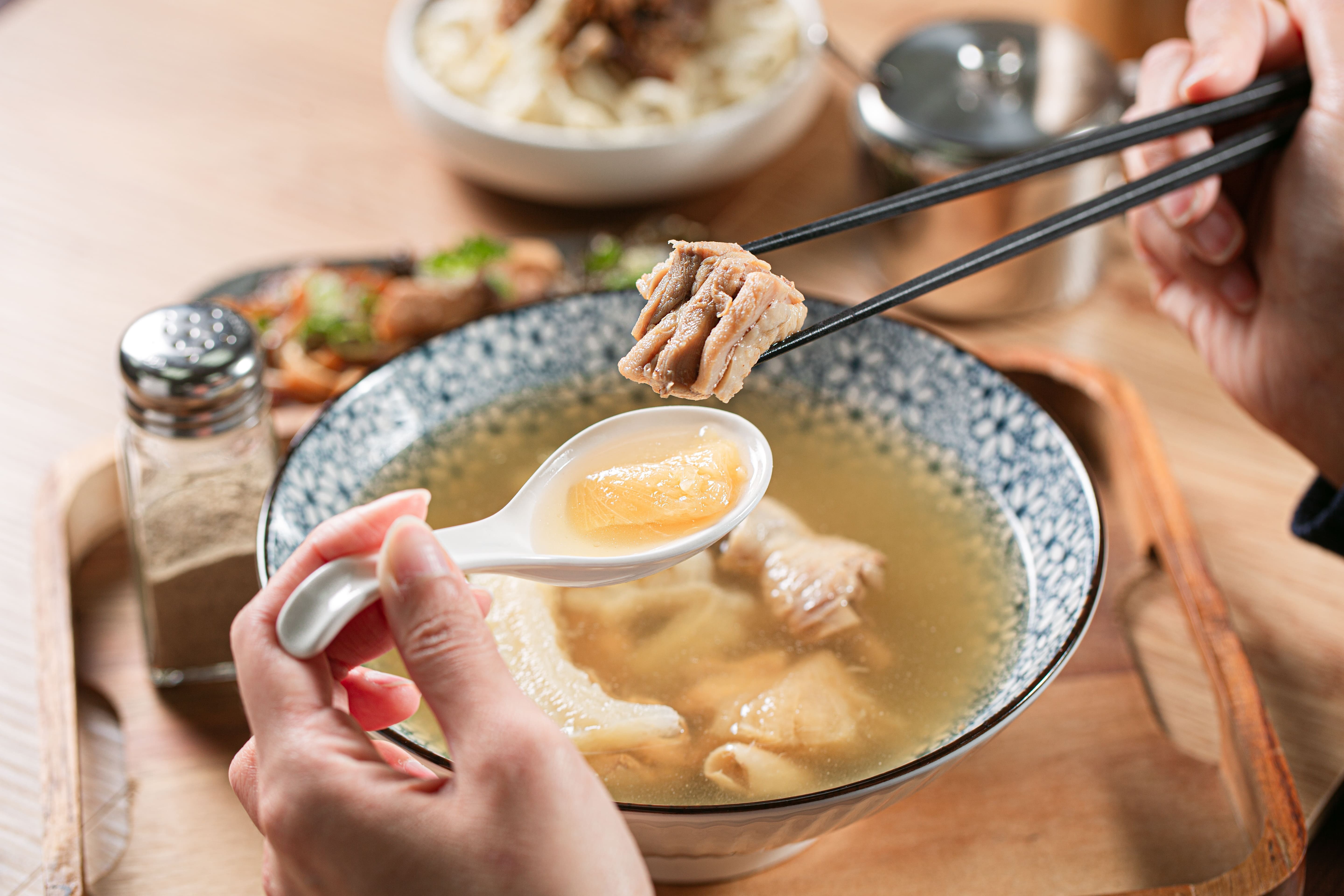 春水良品鳳梨苦瓜雞湯，筷子夾起鮮嫩雞肉並以湯匙盛裝湯料
