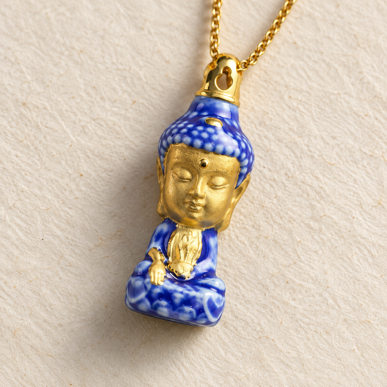 藥師如來精油項鍊特寫,呈現金色佛面、藍白釉色與固定式金色上蓋
