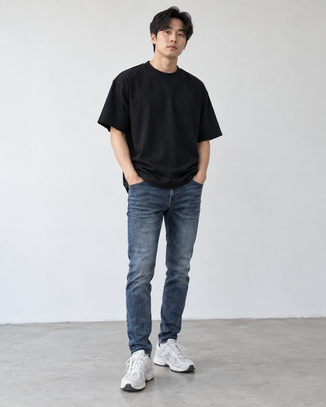 亞洲男生穿黑色重磅寬版素T搭配藍色小直筒牛仔褲