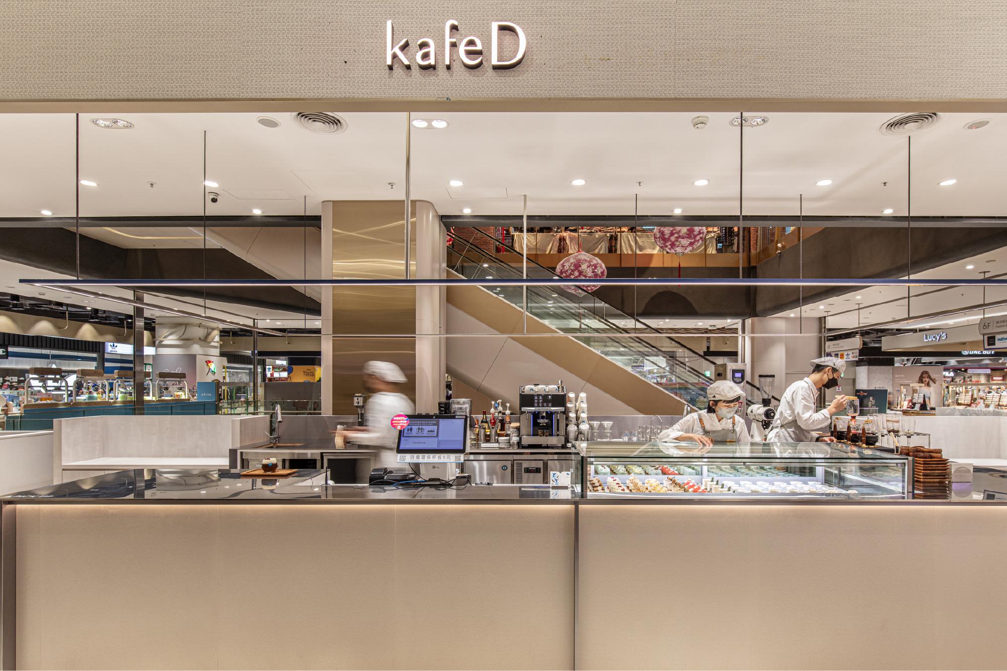 kafeD 實體門市空間,專業咖啡職人在吧檯為顧客準備精緻甜點與手沖咖啡。