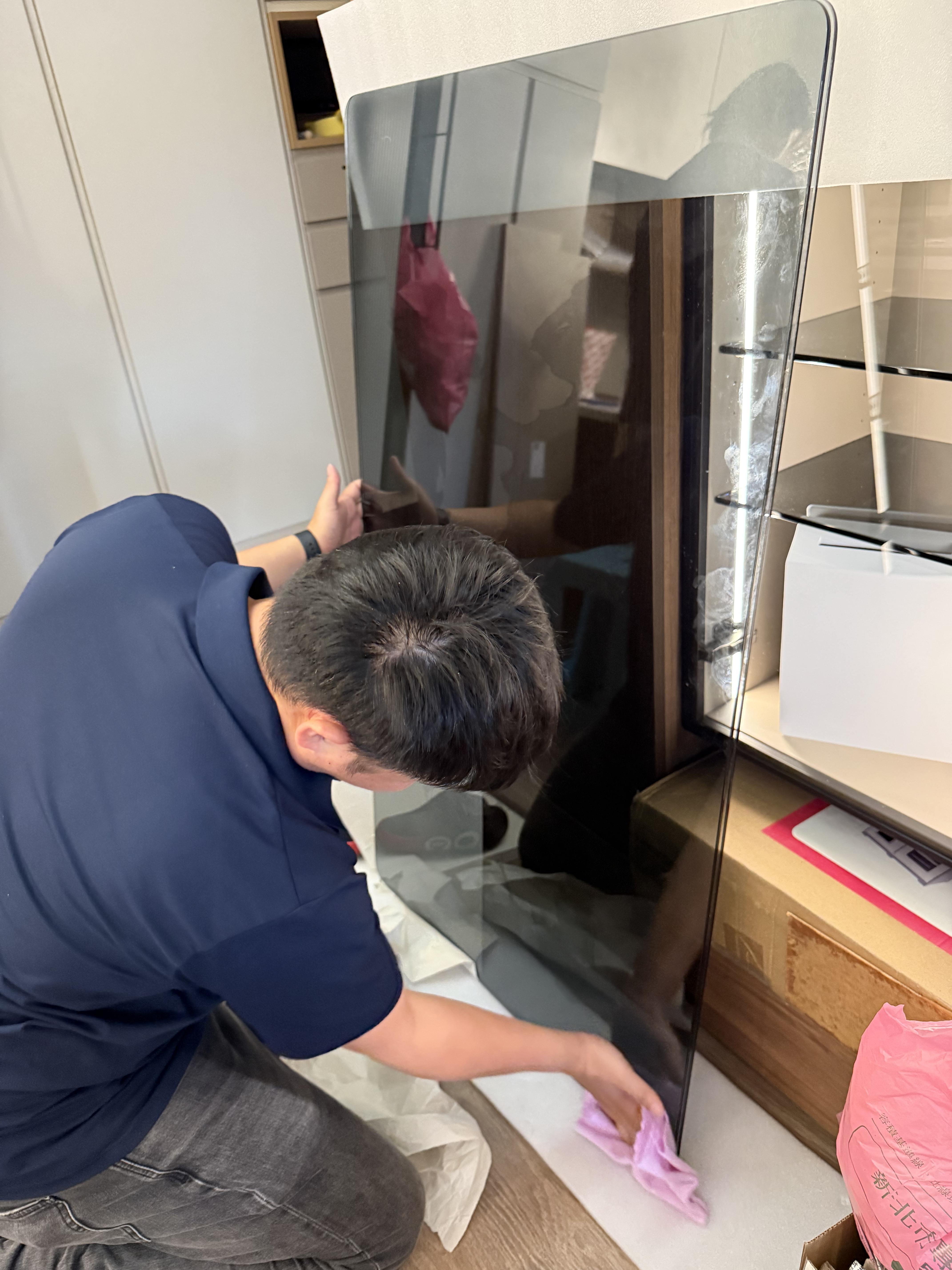 技師細心擦拭與準備強化玻璃