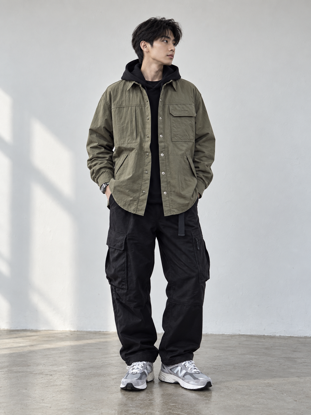 男生黑色帽T外搭軍綠工裝外套與黑色工裝褲