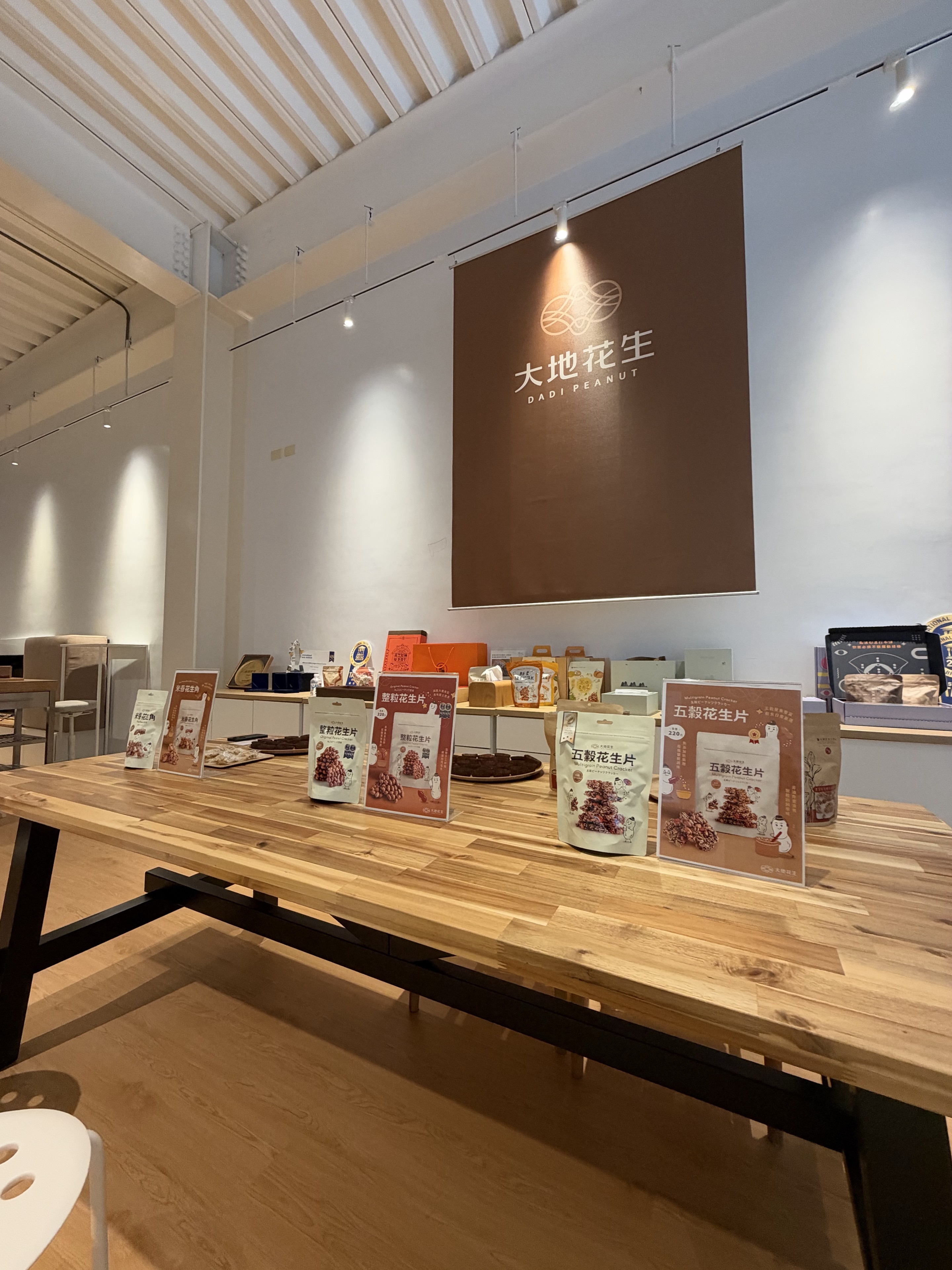 大地花生現場產品展示與試吃桌，背後為品牌標誌