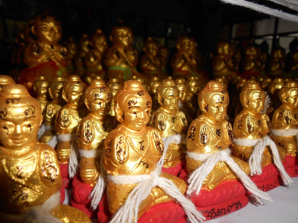 原商品頁古曼童群像近照,金色童子配紅色底座,可見各尊表面的符字與白色線繩