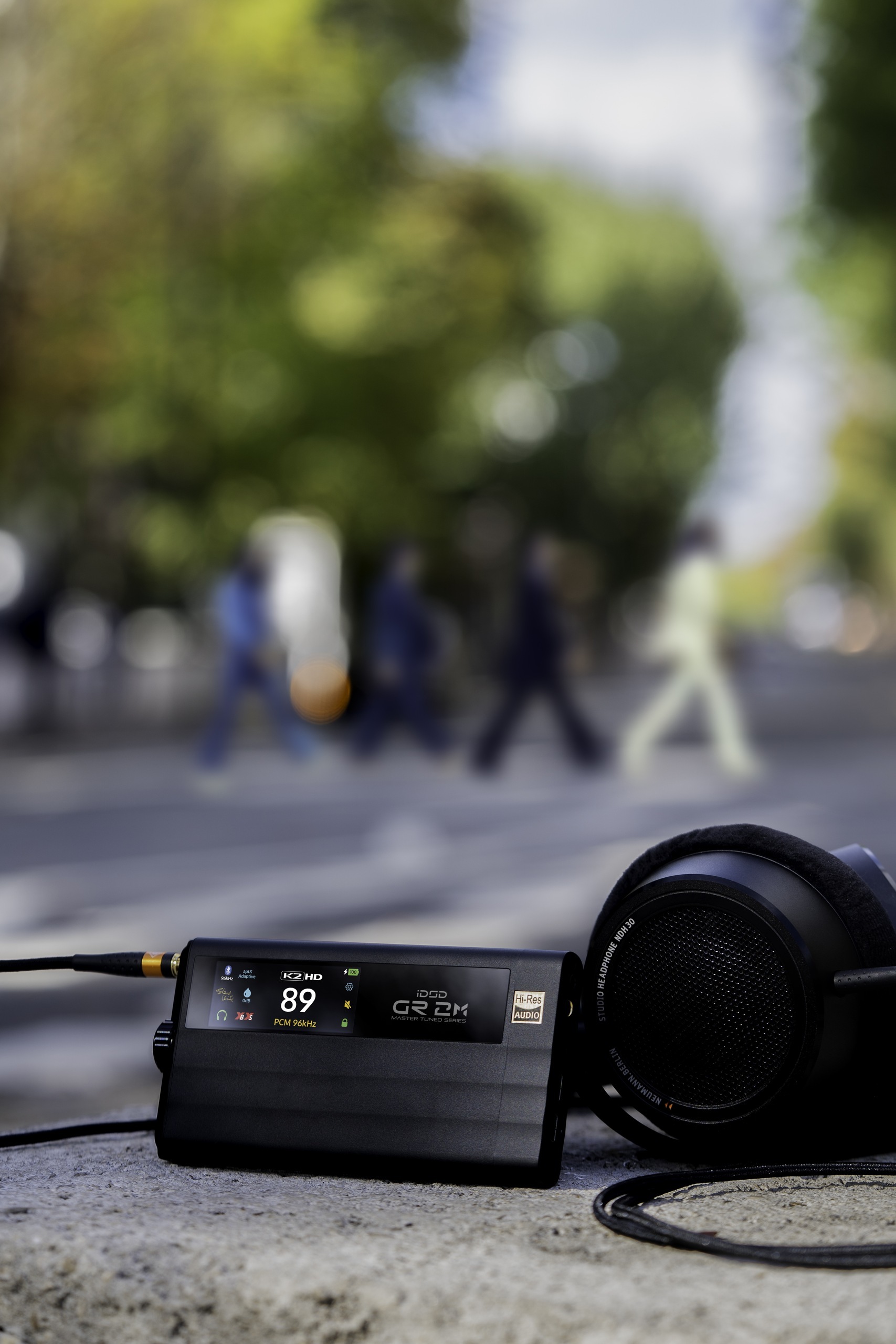 iDSD GR 2 MT beside headphones on a bright outdoor table