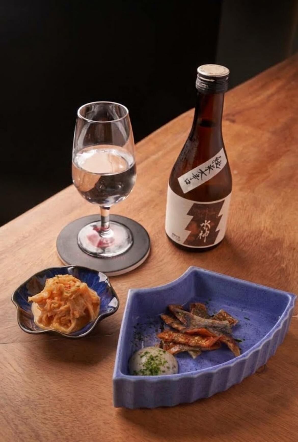 酒桃的清酒、酒杯與金黃泡菜等小料理同框