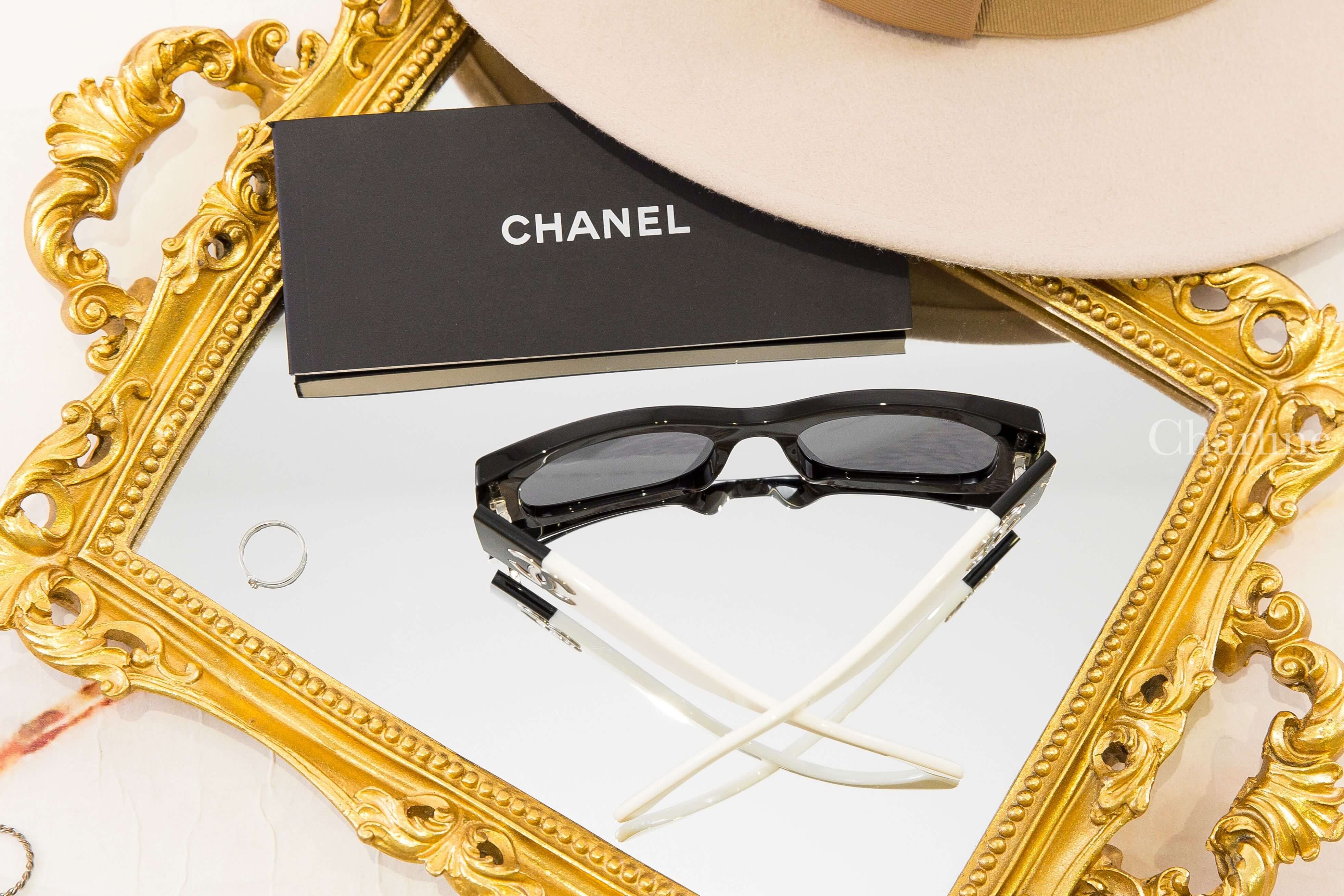 Chanel Rectangle Sunglasses 黑色長方框深灰色鏡片黑白拼色太陽眼鏡，俯視角度展示鏡框內側與交叉白色鏡腳
