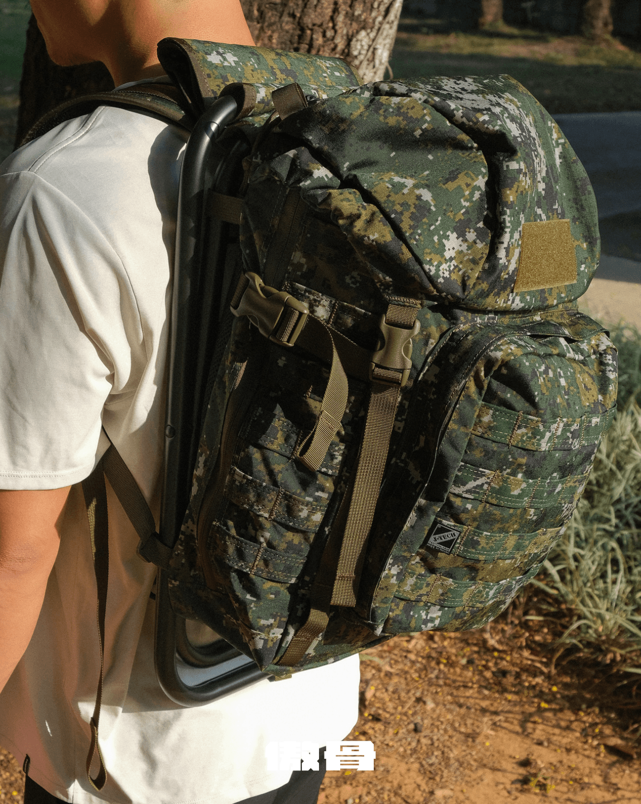 使用者肩背國軍數位迷彩行軍板凳椅背包,展示椅架收合後的雙肩背負方式