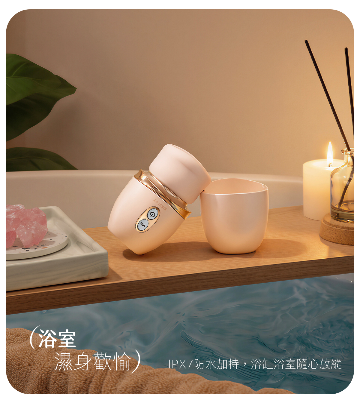Kisstoy 唇之愛舌舔吸啜器擺在浴缸木架上，旁有香薰蠟燭與粉晶，示範IPX7防水可在浴室濕身使用。