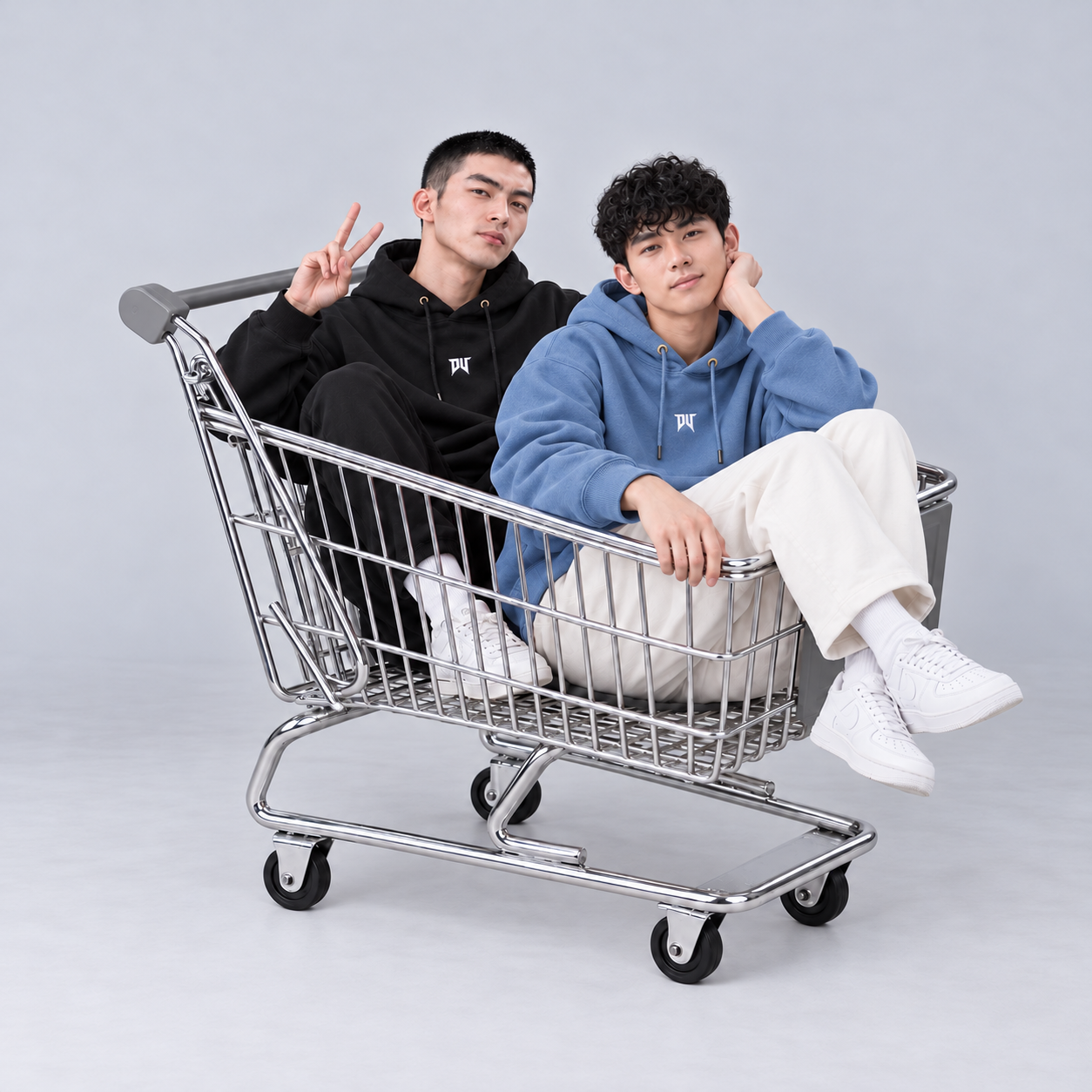 兩位男模穿著冰川藍與黑色DV帽TEE坐在購物車裡