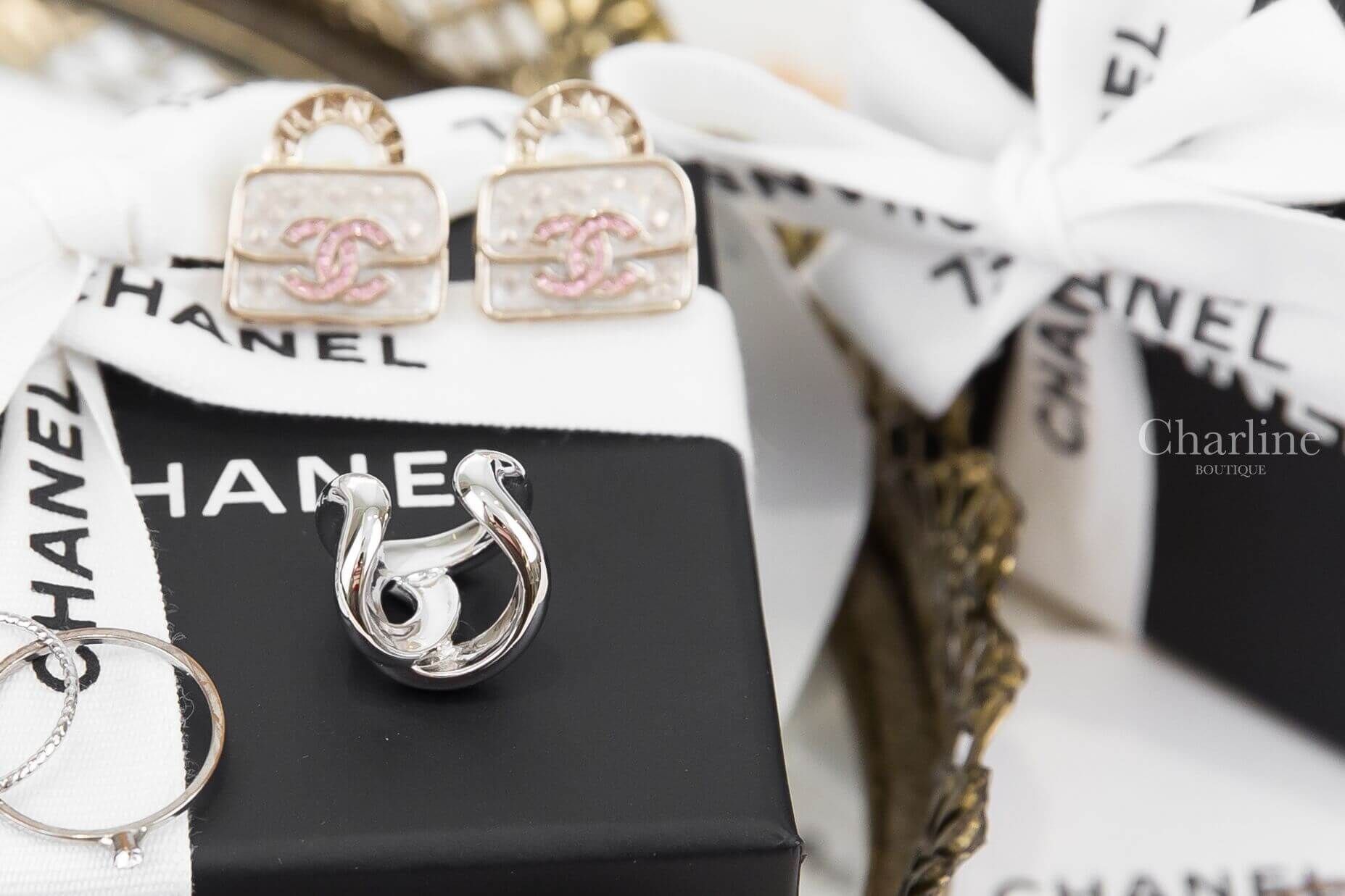 Chanel Cuff 銀色CC耳骨夾 ABI236 B26620 UE915 正面情境照，銀色耳骨夾搭配CHANEL包裝與飾品陳列
