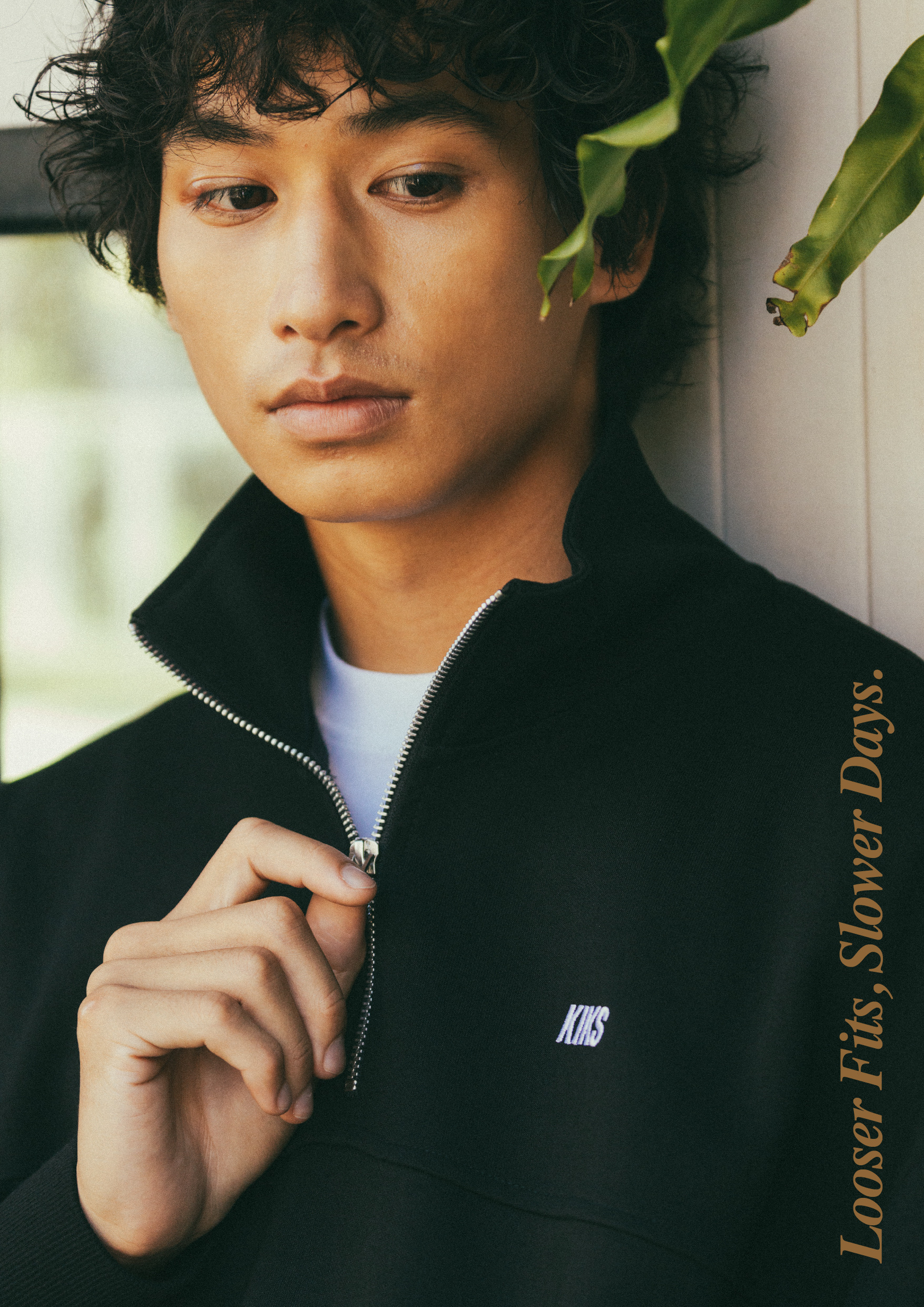 KIKS 黑色拉鍊領口衛衣拉鍊特寫，KIKS 刺繡字樣，Looser Fits, Slower Days. 標語