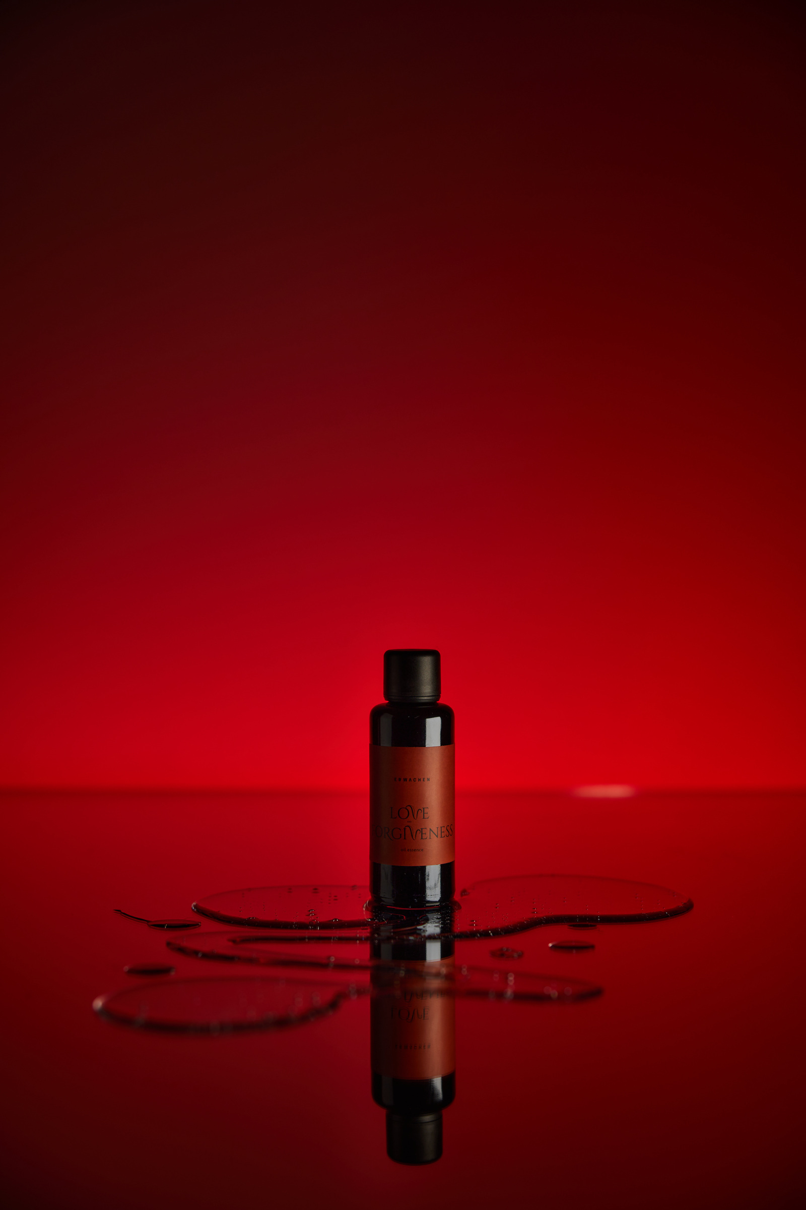 愛與寬恕精華油 50ml 單瓶實拍，酒紅背景與鏡面光影