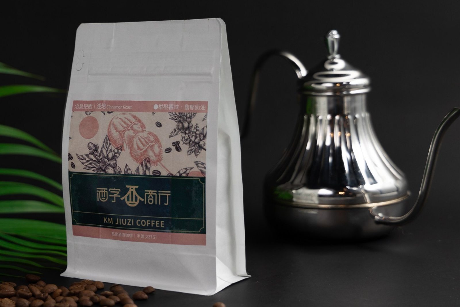 浯島戀歌高粱咖啡半磅包立在深色檯面上,旁邊是不鏽鋼手沖壺和散落的咖啡豆