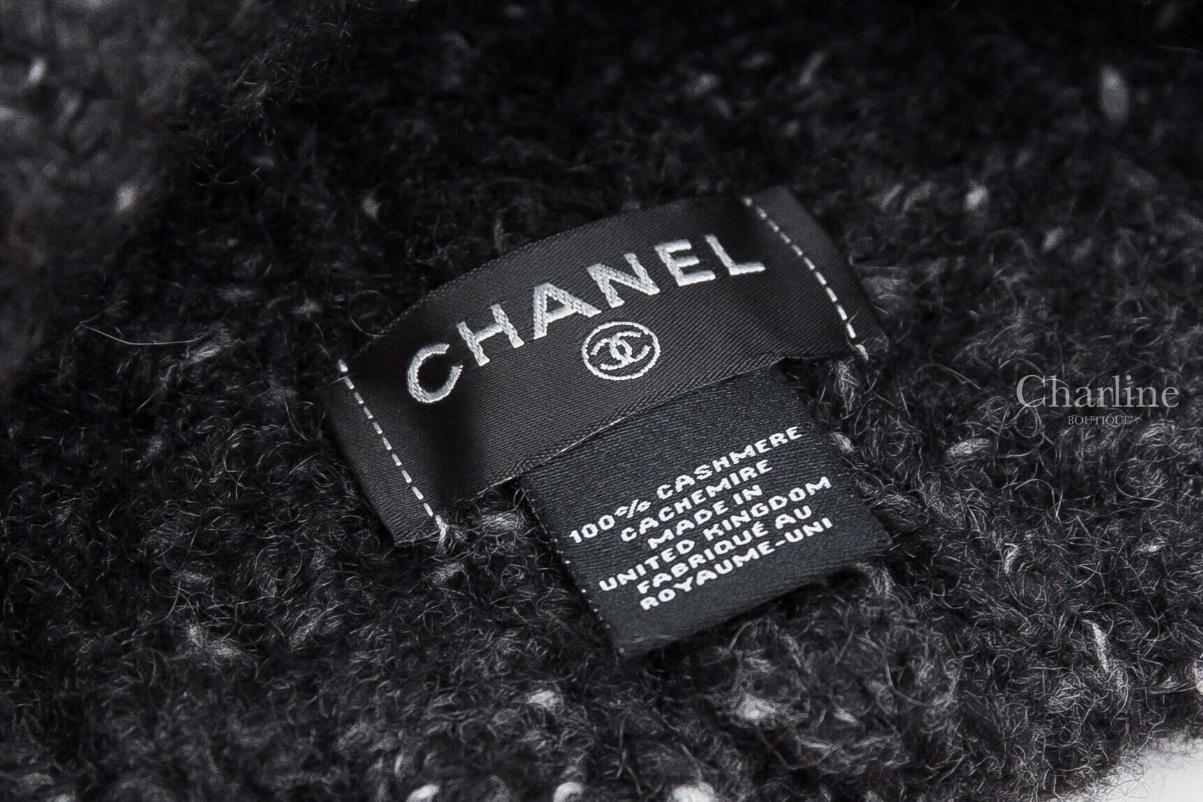 CHANEL 香奈兒黑色喀什米爾毛帽內側標籤特寫，展示 CHANEL 品牌字樣、雙 C 標誌、100% Cashmere 喀什米爾材質標示及 Made in United Kingdom 英國製造資訊。