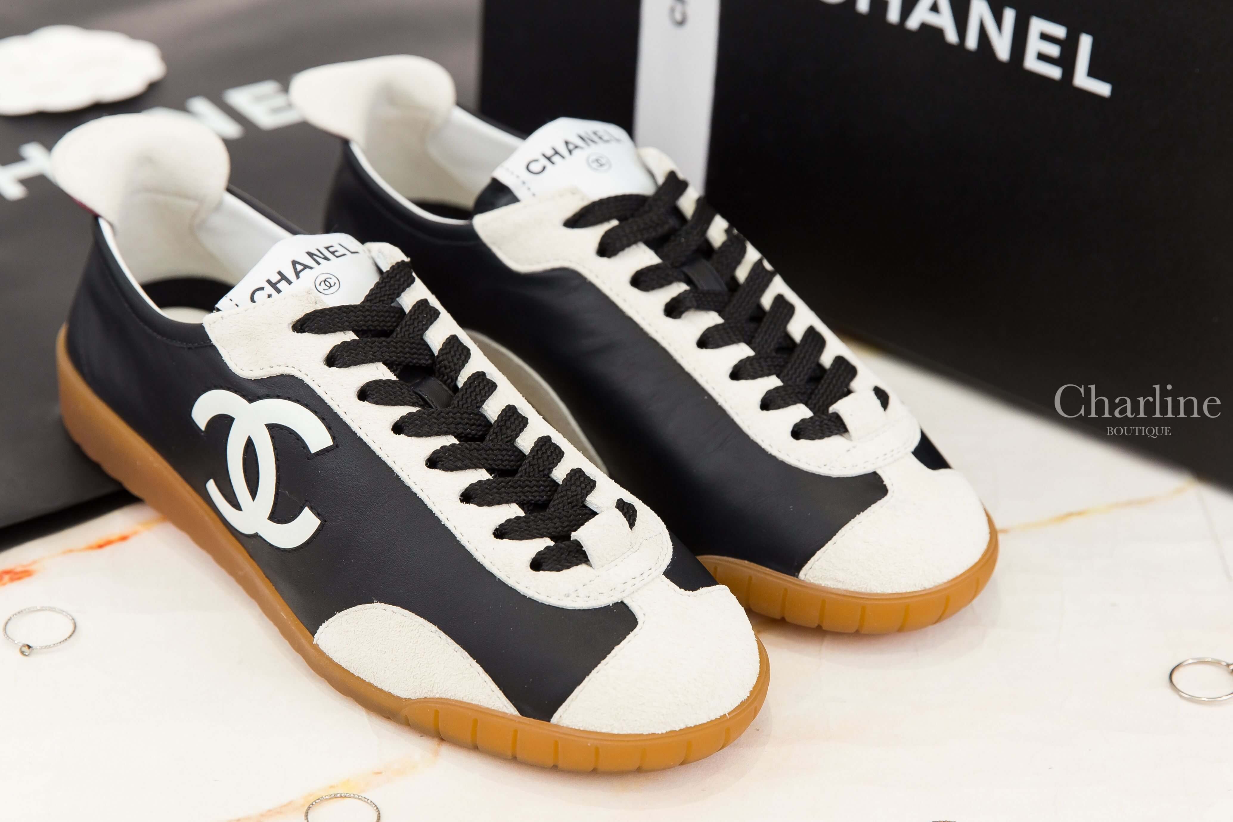 Chanel Trainers 黑色牛皮拼白色麂皮側邊白CC焦糖色鞋底白尾運動鞋 雙鞋正面斜角與黑色鞋帶展示