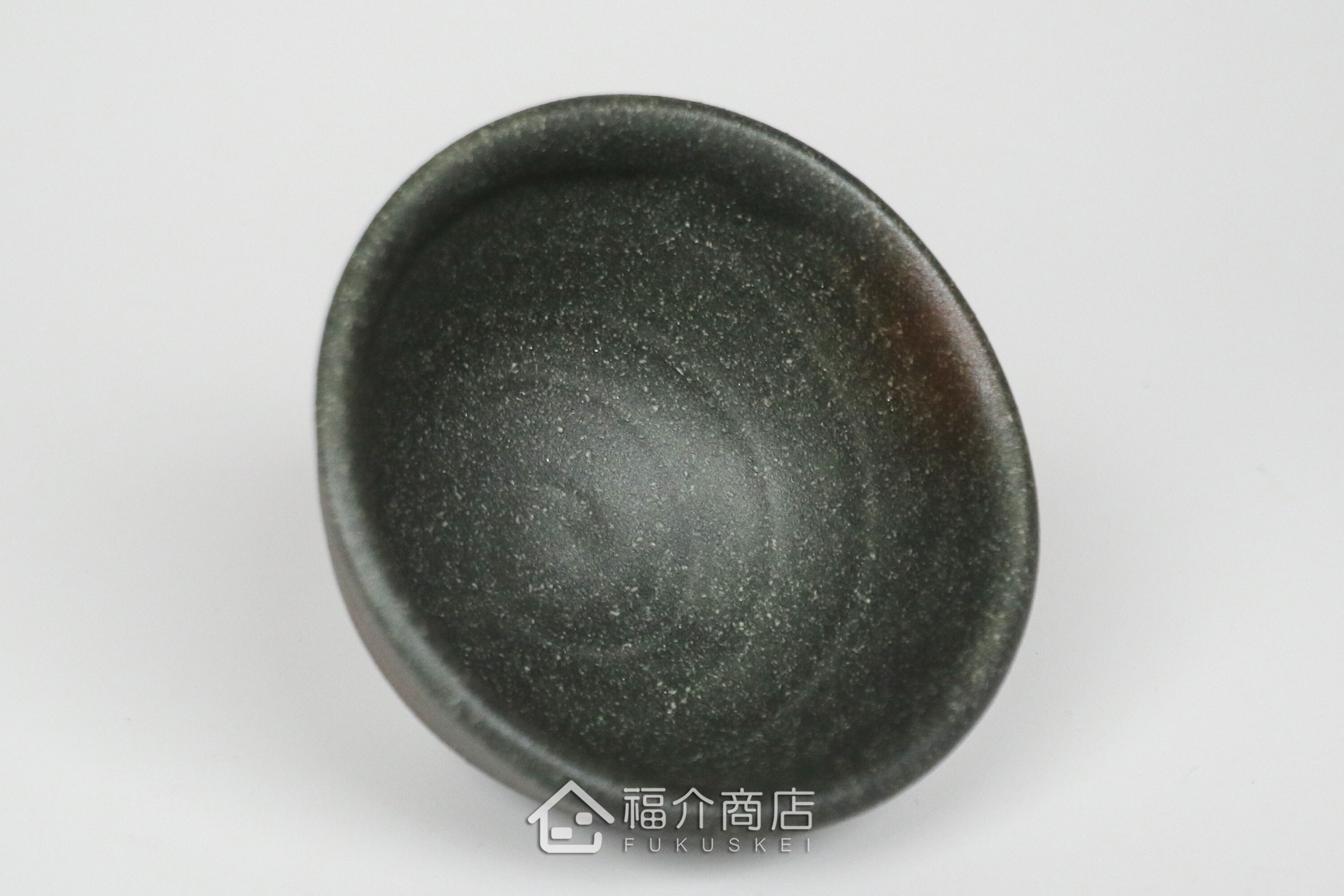 備前手作陶杯以沉穩洗鍊的黑陶質地為底蘊，表面散發著如星芒微閃般的細緻砂質顆粒，為餐桌與品飲時光增添一份低調靜謐的侘寂美學。