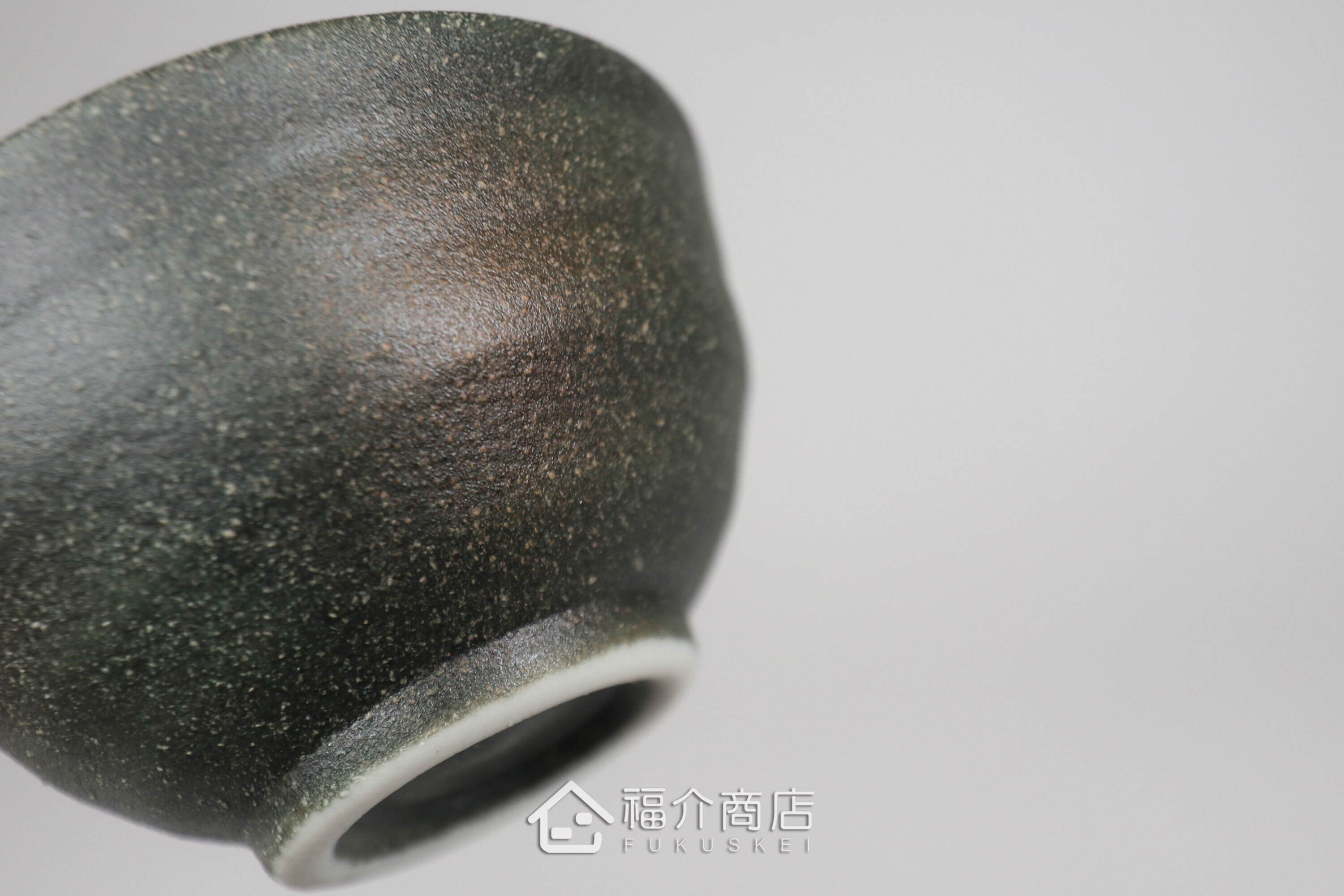 備前手作陶杯以沉穩洗鍊的黑陶質地為底蘊，表面散發著如星芒微閃般的細緻砂質顆粒，為餐桌與品飲時光增添一份低調靜謐的侘寂美學。