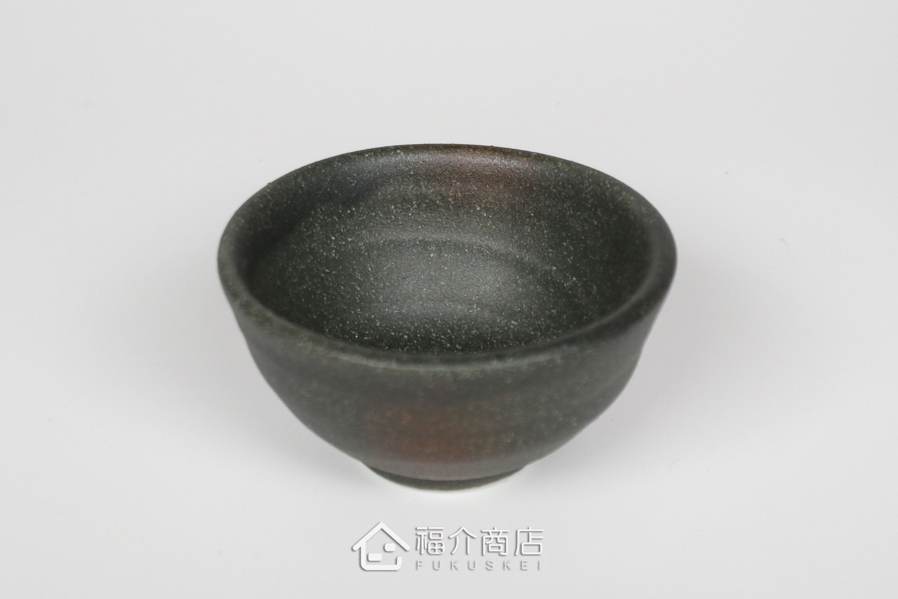 備前手作陶杯以沉穩洗鍊的黑陶質地為底蘊，表面散發著如星芒微閃般的細緻砂質顆粒，為餐桌與品飲時光增添一份低調靜謐的侘寂美學。