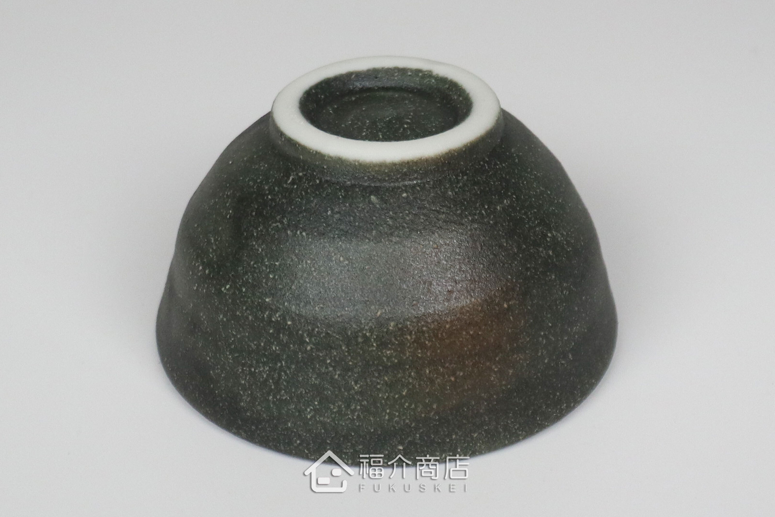 備前手作陶杯以沉穩洗鍊的黑陶質地為底蘊，表面散發著如星芒微閃般的細緻砂質顆粒，為餐桌與品飲時光增添一份低調靜謐的侘寂美學。