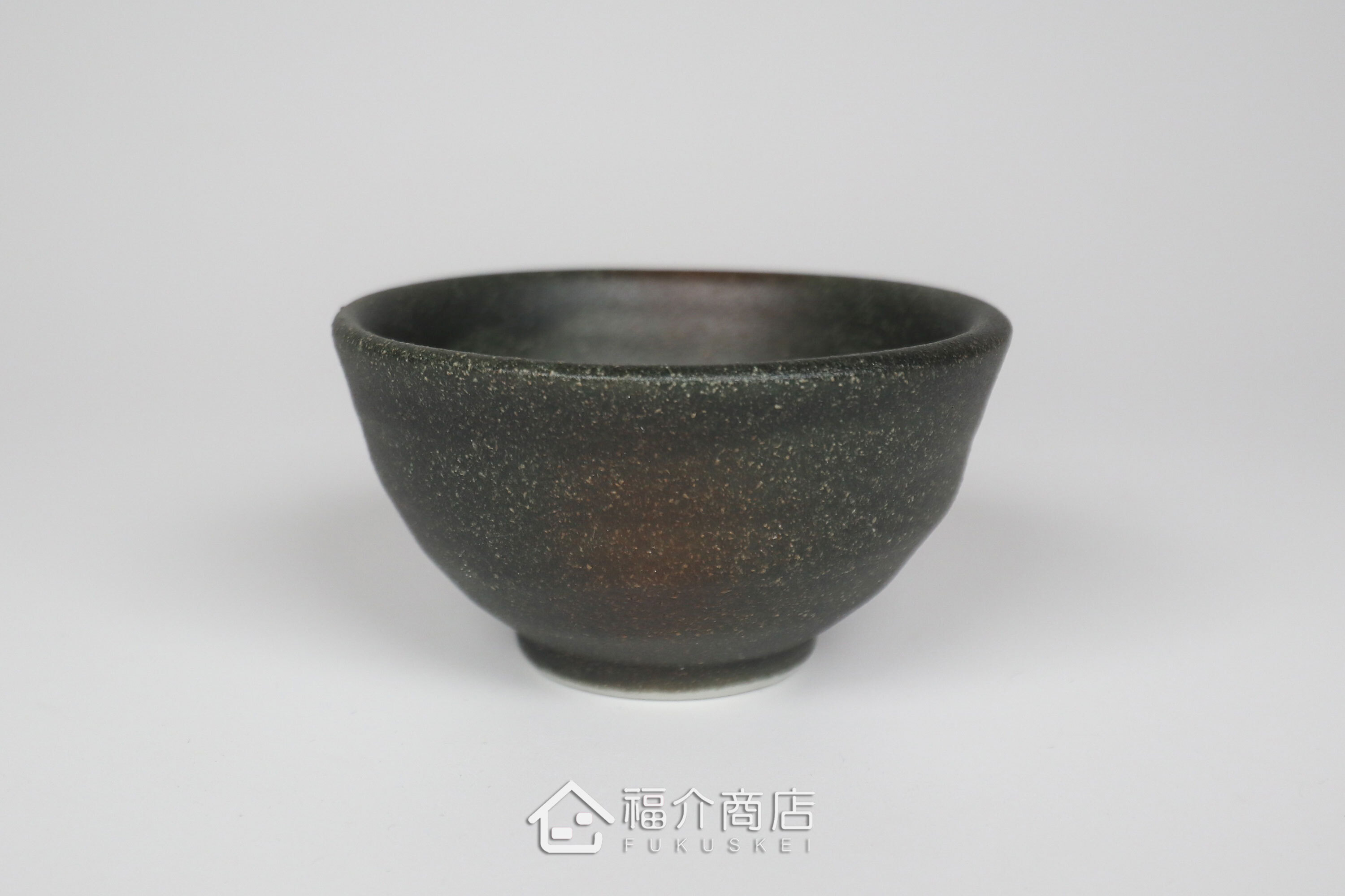 備前手作陶杯以沉穩洗鍊的黑陶質地為底蘊，表面散發著如星芒微閃般的細緻砂質顆粒，為餐桌與品飲時光增添一份低調靜謐的侘寂美學。