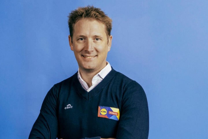 前環法冠軍Andy Schleck身穿Lidl-Trek團隊服裝，於藍色背景前拍攝肖像